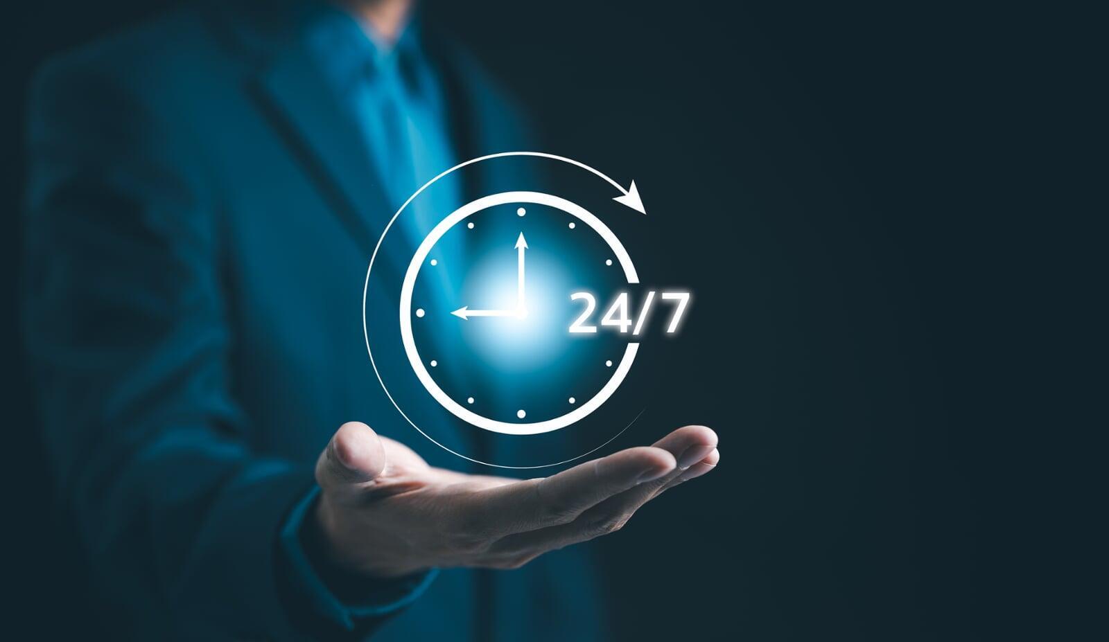 A hand holding a logo of a clock showing 24 /7