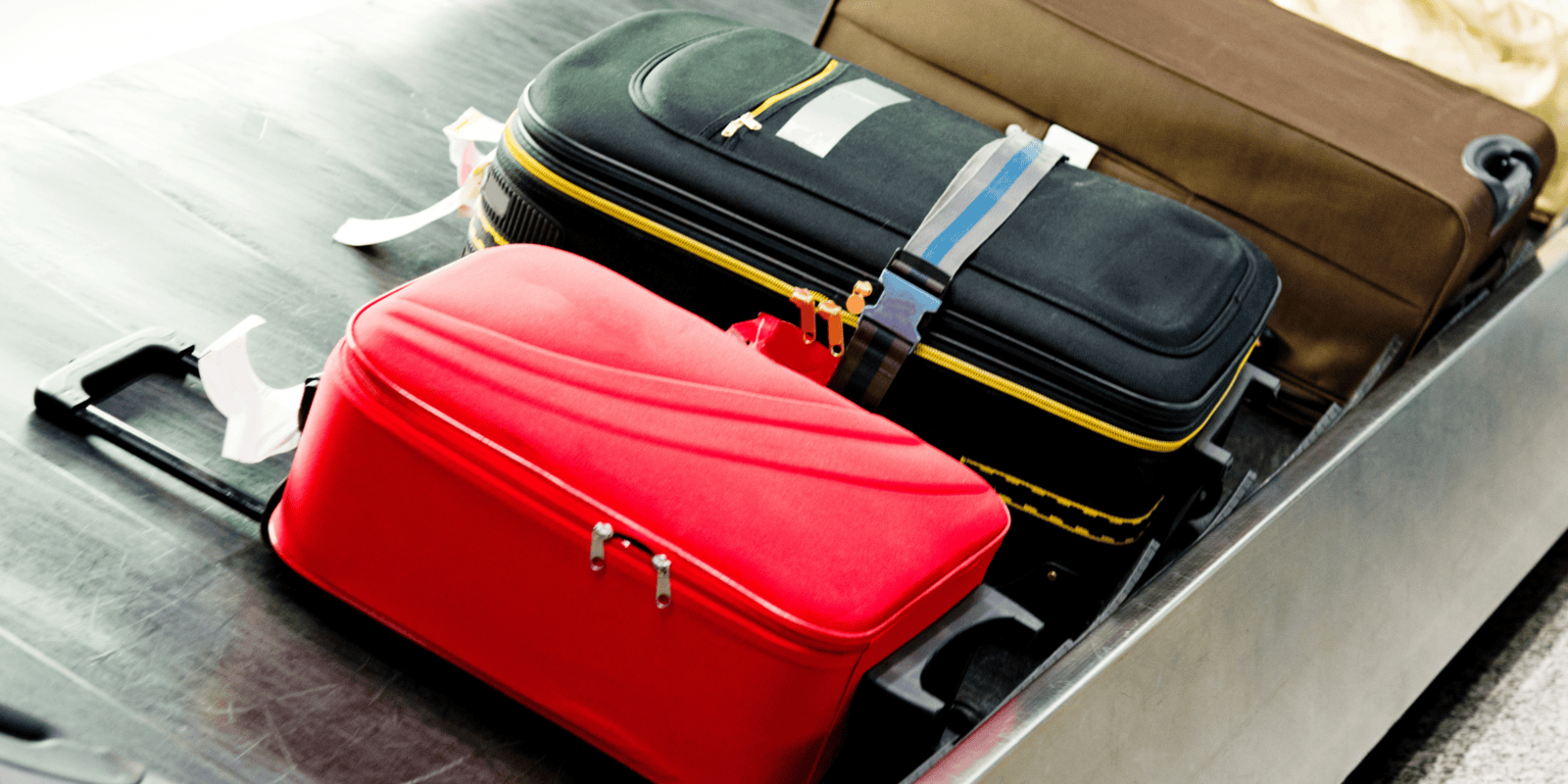 Personal luggage on a conveyor belt at an airport, in black and white