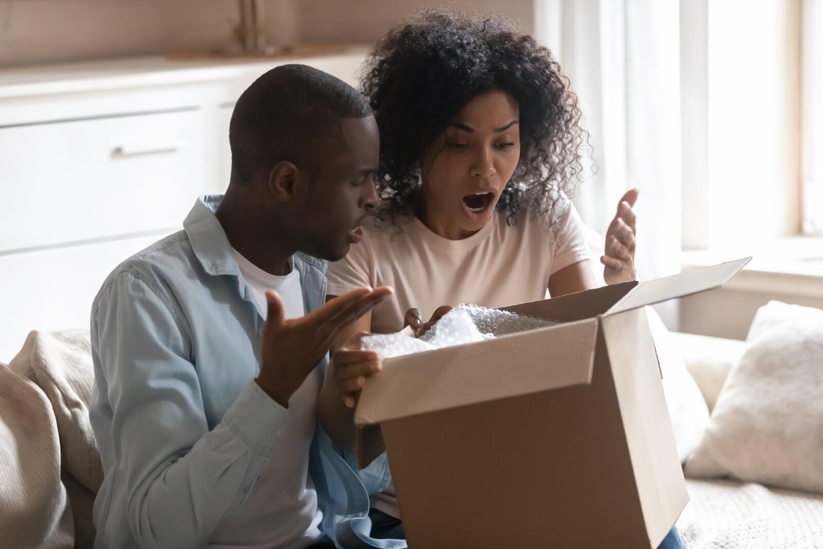 a couple shocked at finding damaged items inside a box